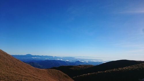 Scenic view of mountains against blue sky