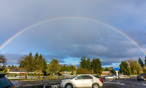 Rainbow over road against sky