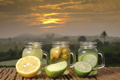 Drinks on table against sky during sunset