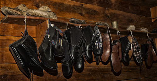 Leather shoes hanging on wooden rack at home
