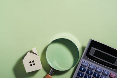 High angle view of calculator and model home on table