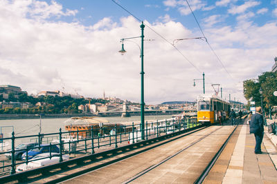 View of tramway in city against cloudy sky