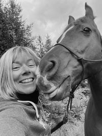 Portrait of smiling young woman with horse