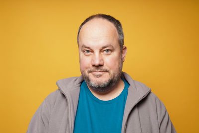 Portrait of man against yellow background