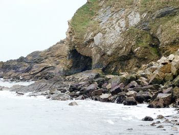 Rock formation by sea against sky