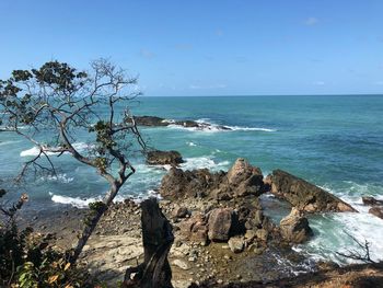 Scenic view of rocks on beach against sky