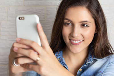 Portrait of smiling young woman using mobile phone