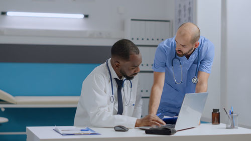 Side view of doctor examining patient in office