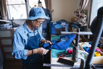 Man working over fabric on table