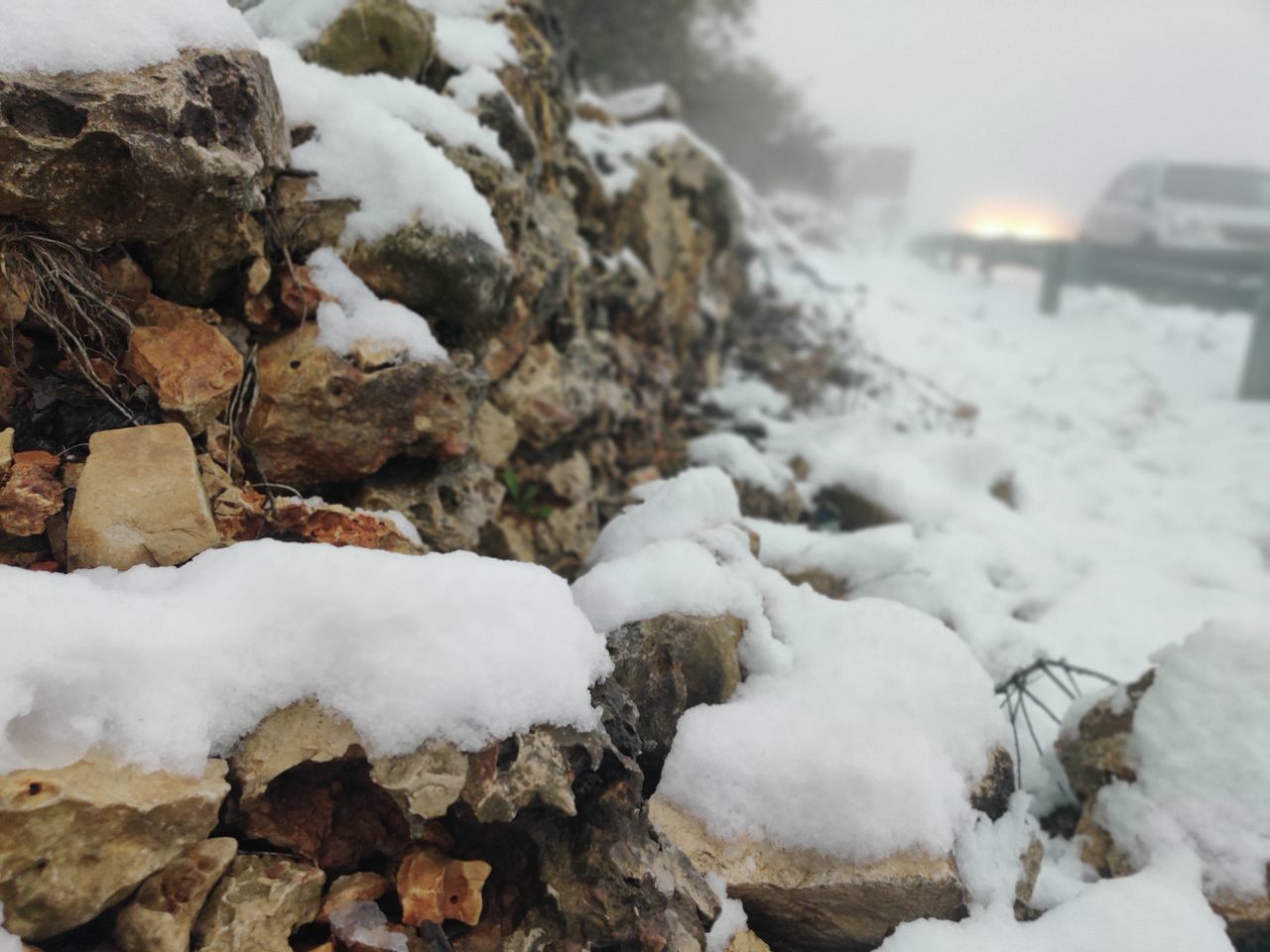 SNOW COVERED ROCKS ON FIELD DURING WINTER