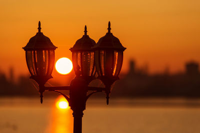 Close-up of street light against orange sky