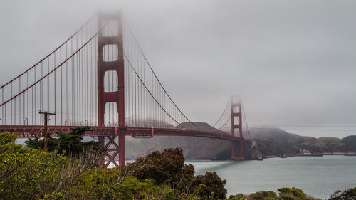 View of suspension bridge against cloudy sky, san francisco