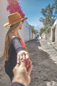 Rear view of woman wearing hat standing on street