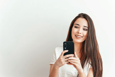 Portrait of a smiling young woman using mobile phone