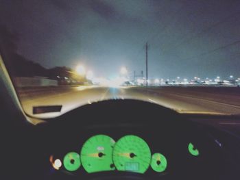 Road seen through car windshield at night
