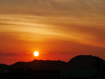 Scenic view of silhouette mountains against romantic sky at sunset