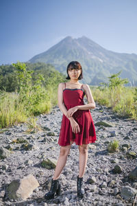 Woman standing on land against mountains