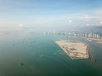 High angle view of cityscape by sea against sky