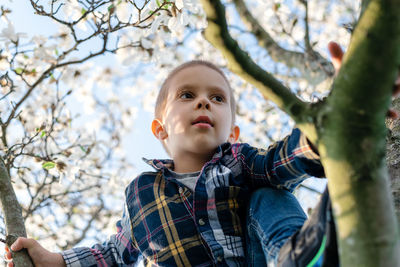 Portrait of cute boy looking away outdoors