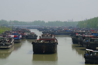 Boats moored in river against sky