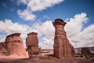 Low angle view of rock formation against cloudy sky