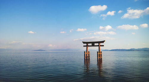 Torii gate in lake biwa against sky