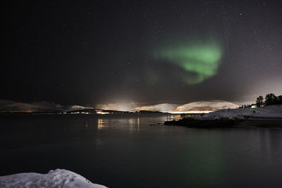 Scenic view of lake against sky at night in tromso with aurora borealis 