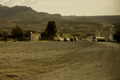 Road amidst field against sky