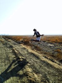 Man riding motorcycle on land against sky