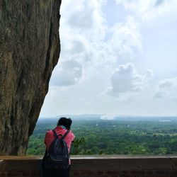 Rear view of woman looking at mountains against sky