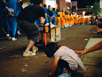 Rear view of people walking on street in city