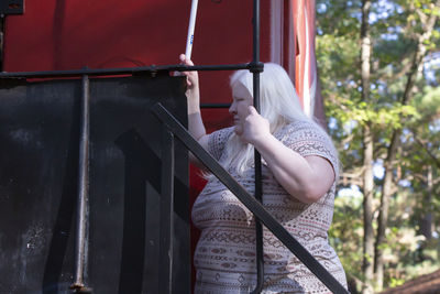 Side view of woman standing by railing