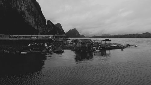 Boats and cabin logs over sea against sky