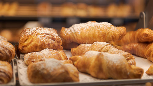 Detail of different pastries behind glass on display in german organic supermarket