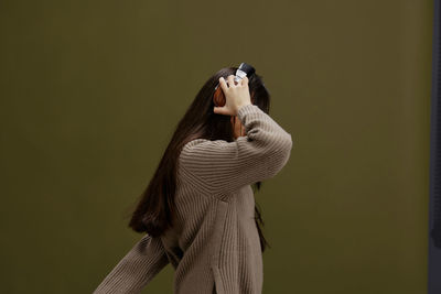 Side view of young woman wearing headphones