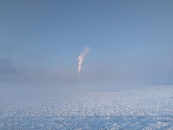 Vapor trail in snow against sky