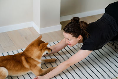 Woman and dog lying on floor