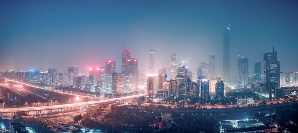 Aerial view of illuminated cityscape against sky at night