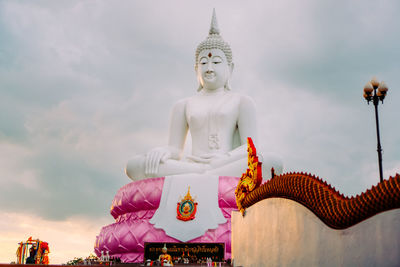 Low angle view of buddha statue against sky