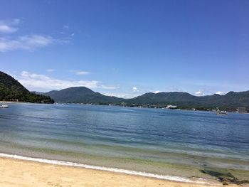 Scenic view of beach against blue sky