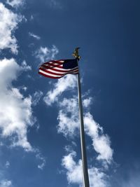 Low angle view of flag against blue sky