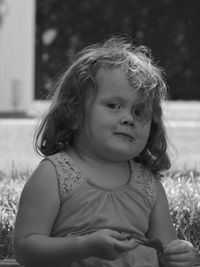 Portrait of cute girl sitting on field