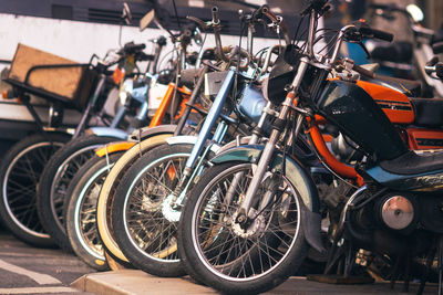 Close-up of vintage bicycles, mopeds and solex in parking lot