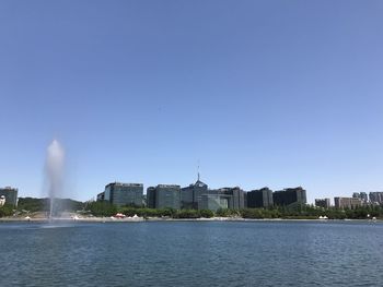 City at waterfront against clear sky