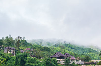 Houses on countryside landscape against mountain range