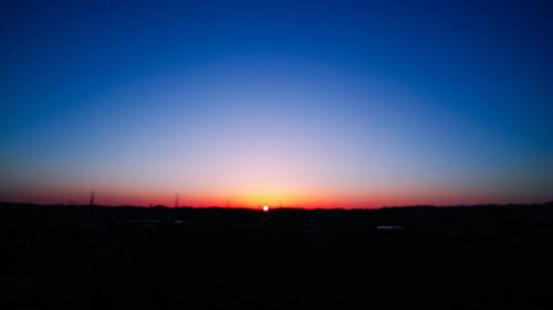 Scenic view of landscape against clear sky at sunset