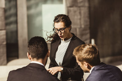 Female entrepreneur discussing business strategy with coworkers while standing outdoors