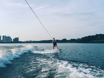 Man surfing in sea against sky