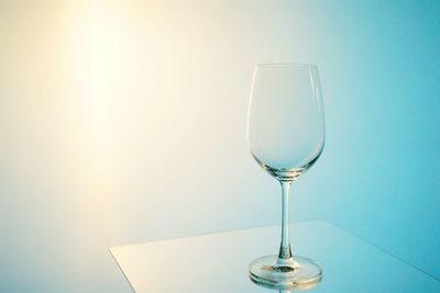 Close-up of wineglass on table against sky