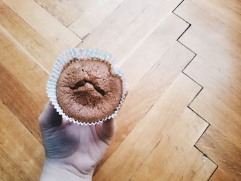 Cropped image hand holding cupcake